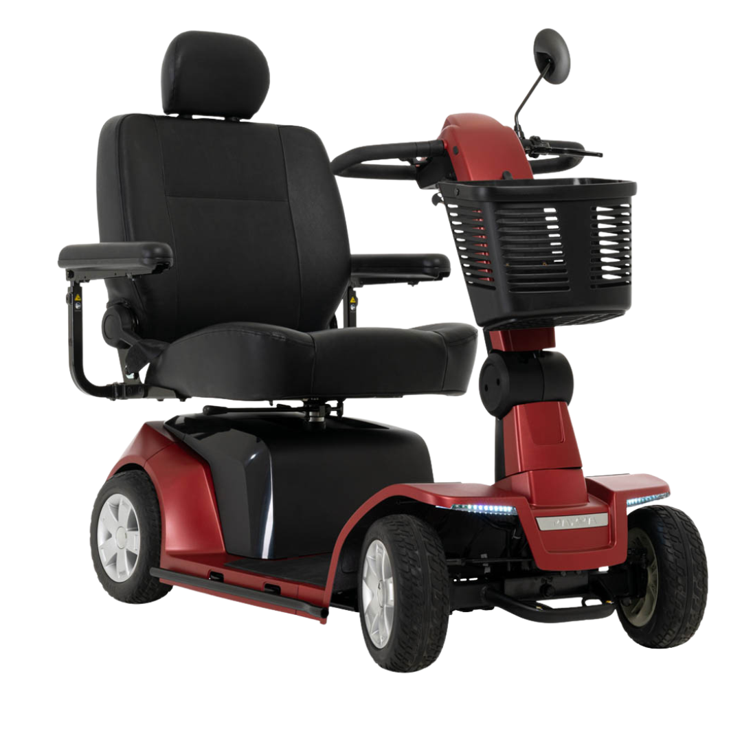 The Pride Mobility Maxima 4-Wheel Bariatric Scooter, shown in red and black against a white background, features a padded seat, armrests, headrest, front basket, LED lighting package, four wheels, and is built for high-weight-capacity users.